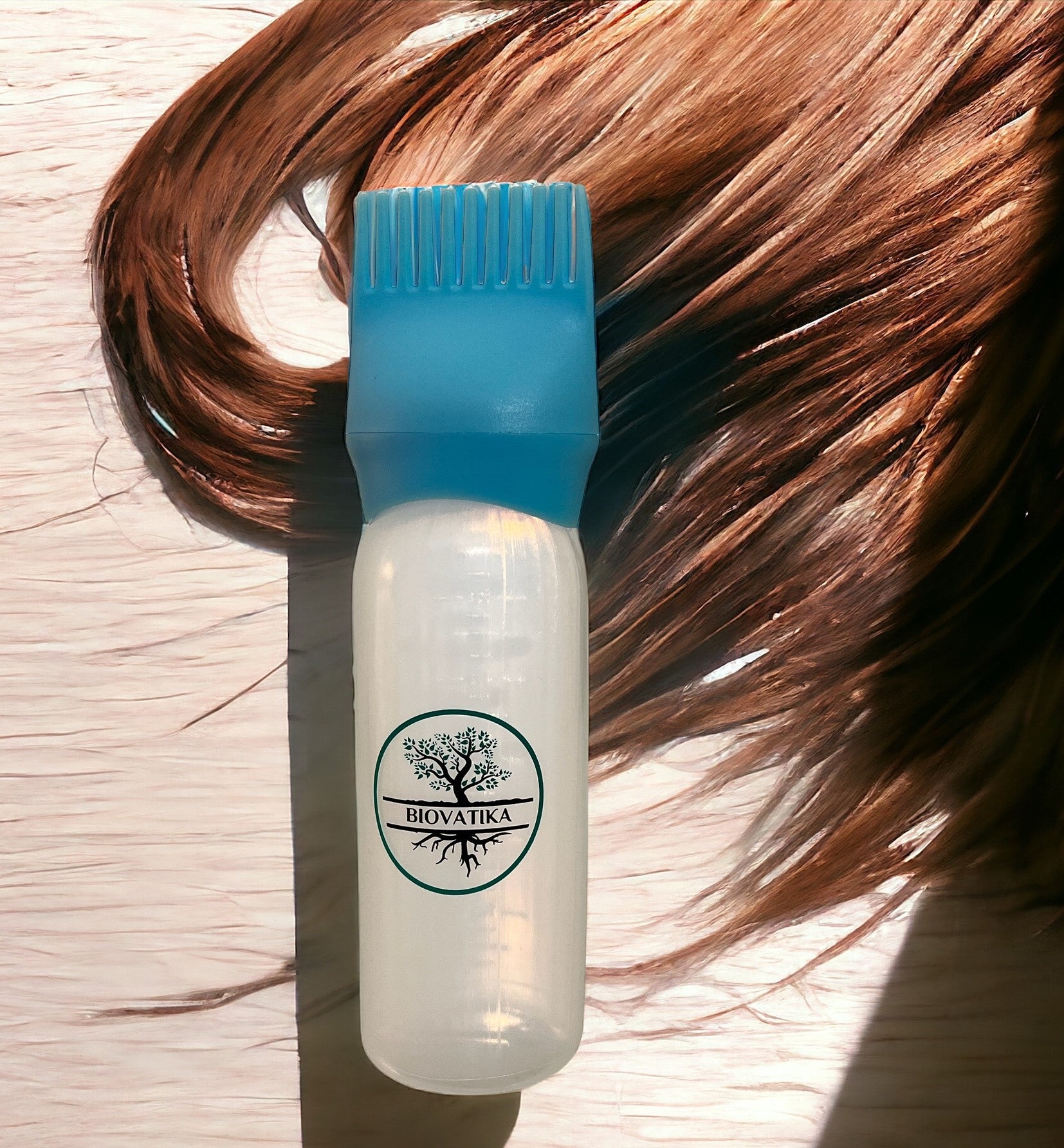 Lahvička s nápisem "BIOVATIKA" s modrým uzávěrem na kartáč spočívá na dřevě vedle hnědých vlasů a obsahuje přípravek Hair Growth Booster 3v1 - šampon, sérum a aplikátor pro podporu růstu vlasů.